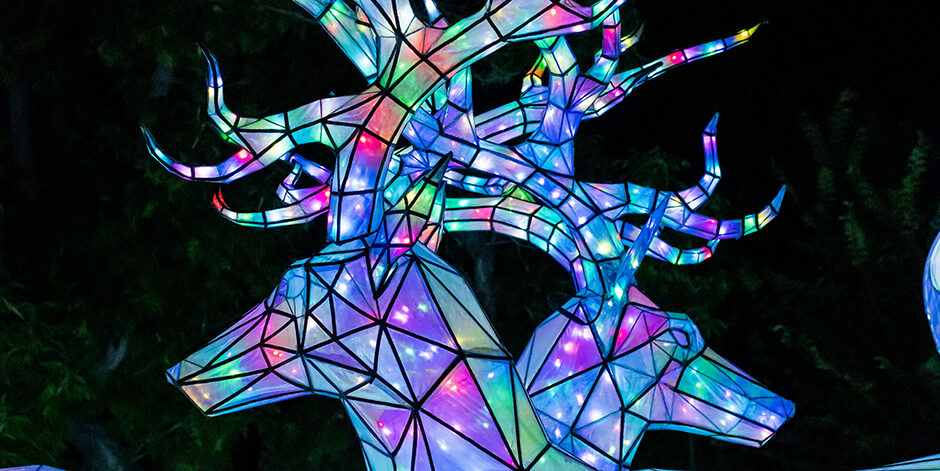 Colorful, geometric deer sculptures illuminated at night