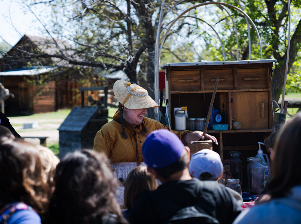 Group listening to a woman in historic attire outdoors