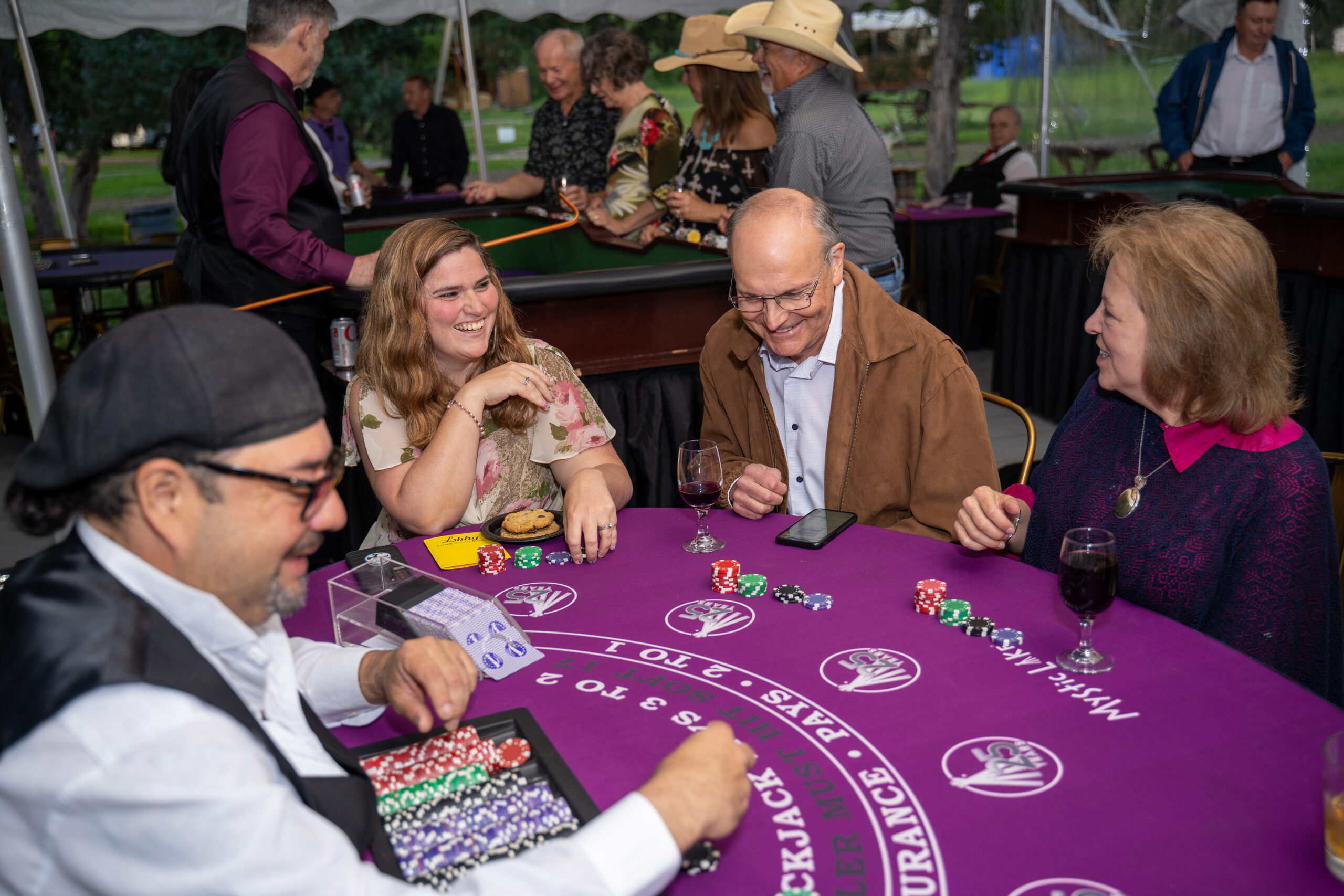 People playing poker at a gala event, smiling.