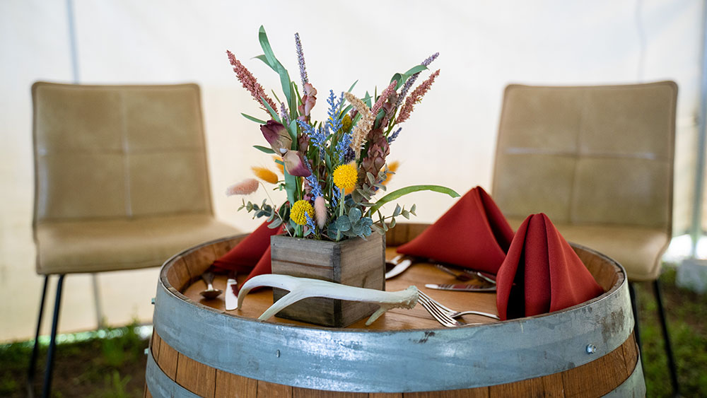 Floral centerpiece on barrel table with red napkins
