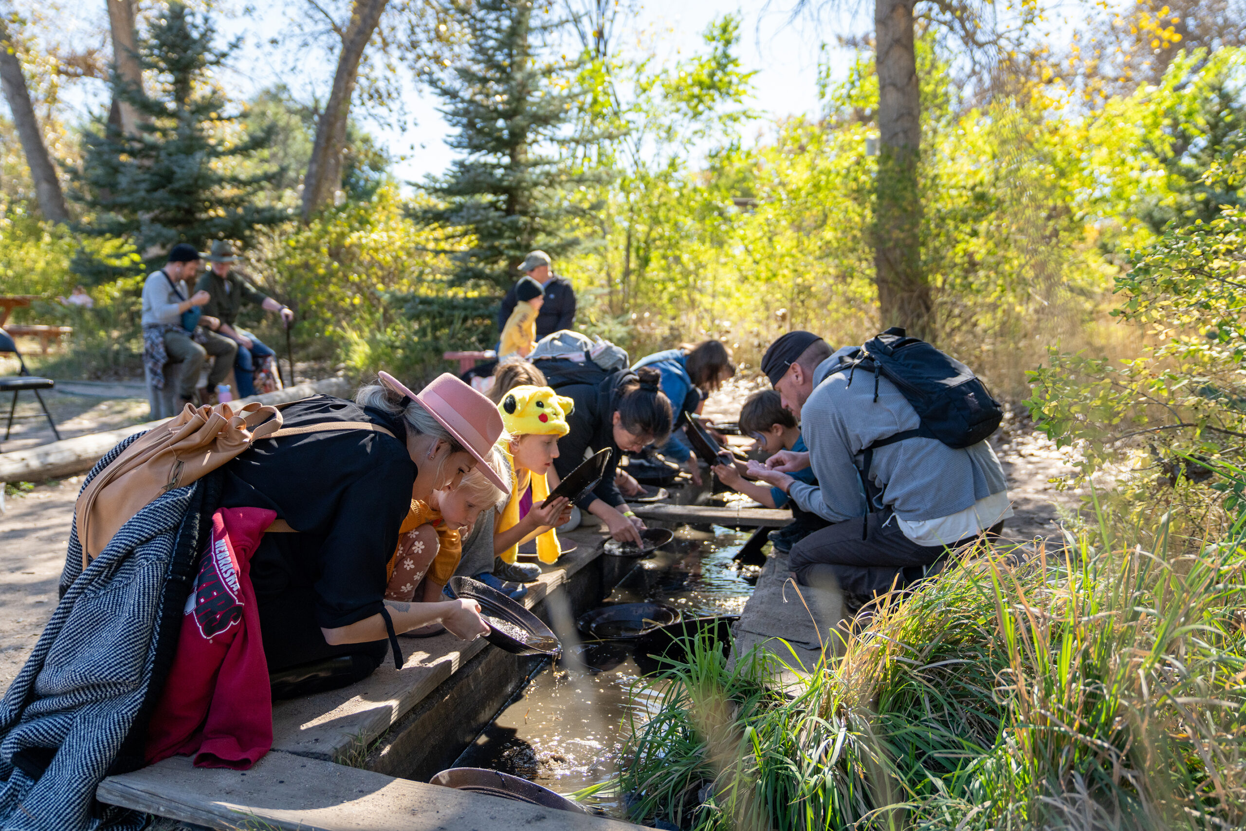 A group of people panning for gold outdoors.