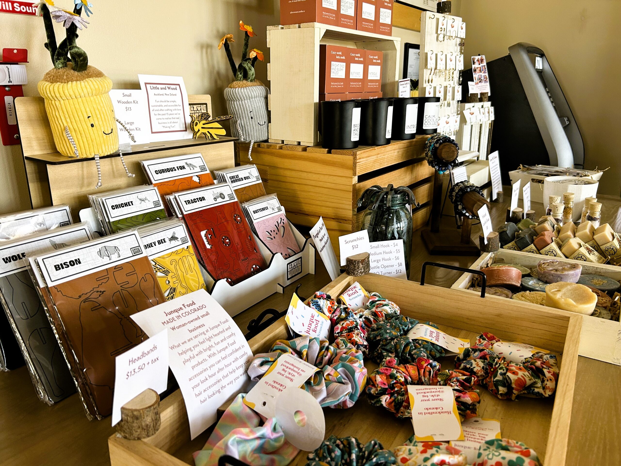 Craft shop display with scrunchies, cards, and pottery items.