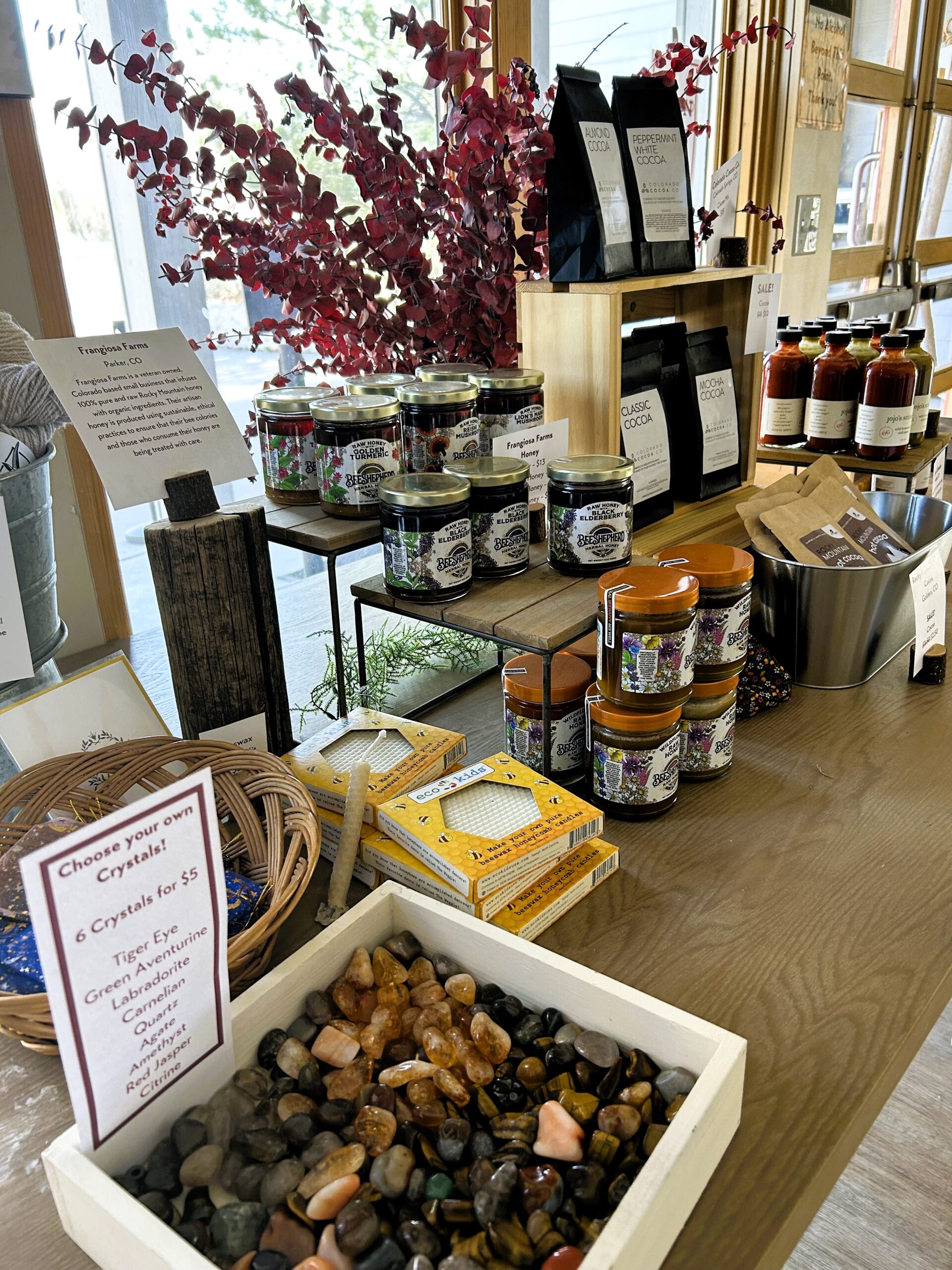 Assorted farm products and crystals for sale with signs