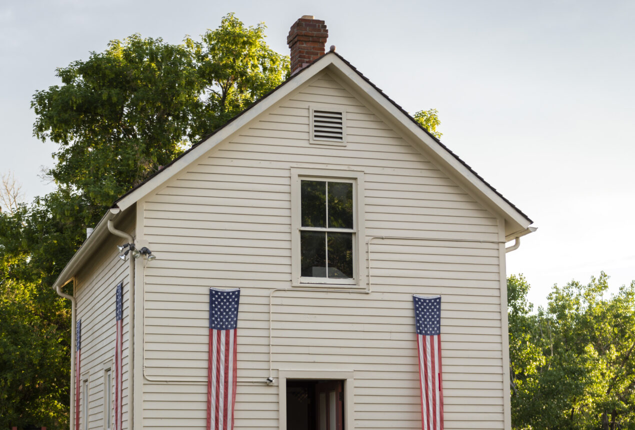 White house with American flags, surrounded by green trees